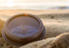 Ancient compass on the sand at the Beach Sunrise ,nature background.